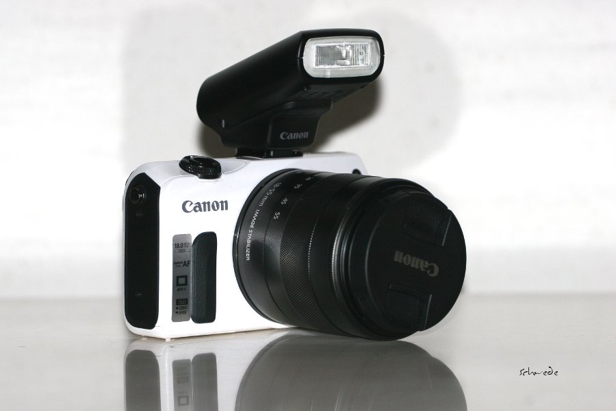 Der Lieferumfang umfasst die EOS M Dogitalkamera, das 18 mm Standardzoom mit Bildstabilisator, den Aufsteckblitz, einen Tragegurt, einen Akku und ein Ladegerät, ein USB-Kabel, ein Handbuch und Bildbearbeitungssoftware.