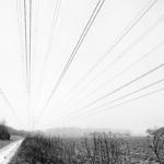 Landschaft mit Strommast und Leitungen