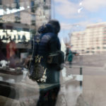 Spiegelung - Ein Boutique hat ihre Fenster rund herum mit alten Nähmaschinen dekoriert.